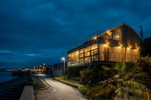 a building next to a river at night at Yokosuka Sky Grey -横須賀のビーチフロントベース- in Yokosuka
