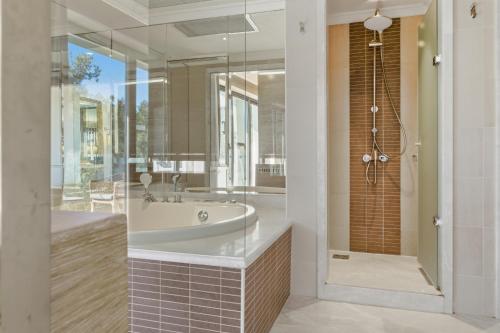 a bathroom with a tub and a walk in shower at Ela Excellence Resort Belek in Belek