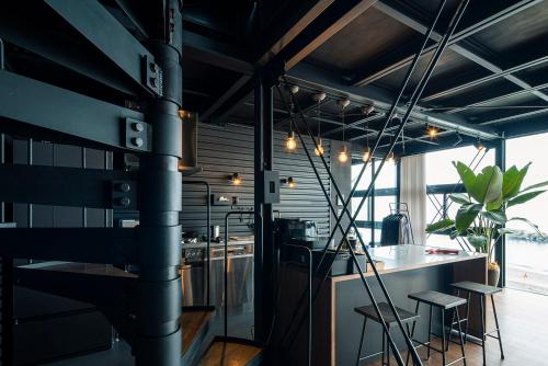 a kitchen with a stove and a table in a room at Yokosuka Sky Grey -横須賀のビーチフロントベース- in Yokosuka