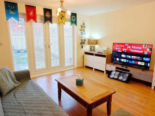 a living room with a couch and a tv at Bright 4BR Family Retreat mins from Harry Potter in Leavesden Green