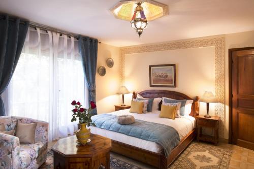 a bedroom with a bed and a chair and a window at Villa Quieta in Essaouira