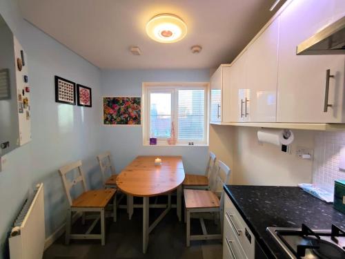 a kitchen with a wooden table and chairs in a kitchen at Bright 4BR Family Retreat mins from Harry Potter in Leavesden Green