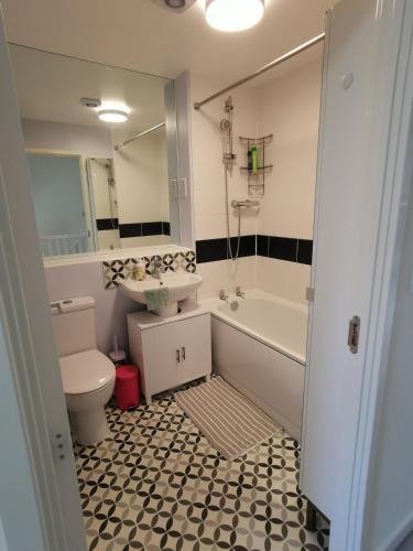 a bathroom with a tub and a sink and a toilet at Bright 4BR Family Retreat mins from Harry Potter in Leavesden Green