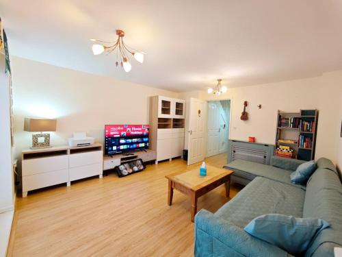 a living room with a couch and a tv at Bright 4BR Family Retreat mins from Harry Potter in Leavesden Green
