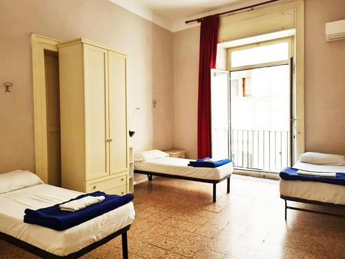 a room with two beds and a large window at 6 Small rooms in Naples