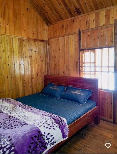a bedroom with a bed in a wooden cabin at MaMa ShuShu Homestay in Sapa