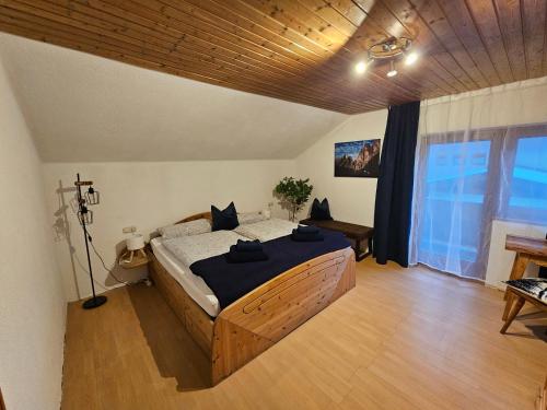a bedroom with a large bed with a wooden ceiling at Ferienwohnung Bergherz in Sankt Johann im Walde