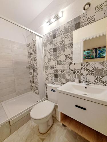 a bathroom with a toilet and a sink and a shower at Nomads Rooms in Tríkala
