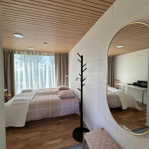 a bedroom with a bed and a mirror at RUSKA-mökki in Tyrnävä