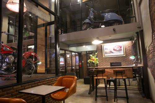 a room with a table and a motorcycle on the wall at The 8 Factory Hotel Phitsanulok in Phitsanulok