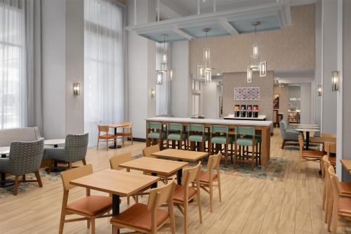 a restaurant with tables and chairs and a bar at Hampton Inn and Suites Fayetteville, NC in Fayetteville