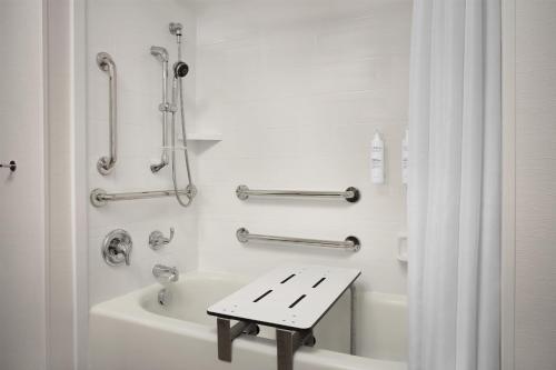 a bathroom with a bath tub and a bench in it at Hampton Inn and Suites Fayetteville, NC in Fayetteville