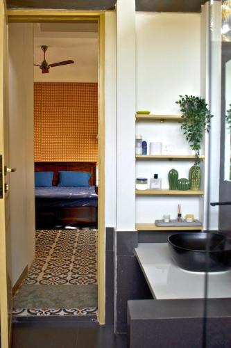a bathroom with a sink and a bedroom with a bed at A Modern 2BHK Private Villa in Vagator - Valenades in Vagator