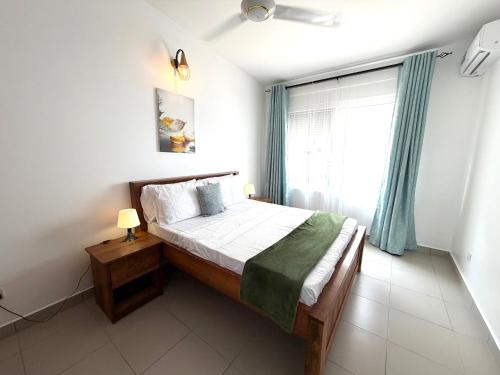 a bedroom with a bed and a large window at Nashu Three bedroom Townhouse in Dambani