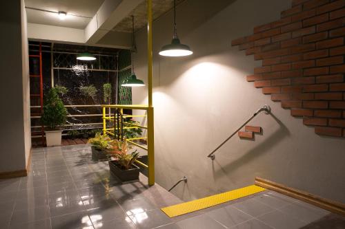 un pasillo con plantas en la pared de un edificio en The 8 Factory Hotel Phitsanulok, en Phitsanulok