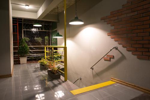 a hallway with plants on the wall of a building at The 8 Factory Hotel Phitsanulok in Phitsanulok
