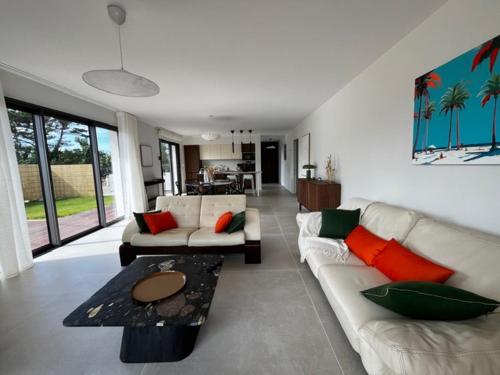 a living room with a couch and a table at Ty Rosc'OFF, Plain-pied de charme, tout récent, à proximité immédiate du centre de Roscoff in Roscoff