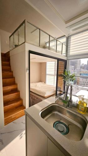 a kitchen with a sink and a bed in a room at Arbo Unit in Seoul