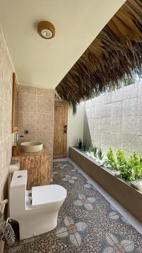 a bathroom with a toilet and a sink at Oemau Bungalow in Nembrala