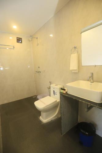 a bathroom with a white toilet and a sink at Molly's Nest in Mandrem
