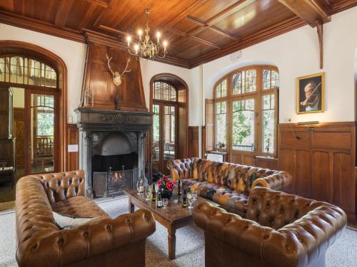 a living room with leather furniture and a fireplace at Beautiful castle in Spa wit garden in Spa