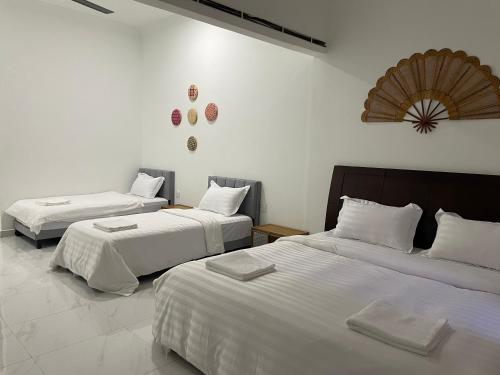 a bedroom with two beds with white sheets at Sanyan Retreat in Jeram