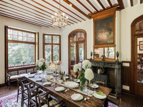 a dining room with a table with flowers on it at Beautiful castle in Spa wit garden in Spa