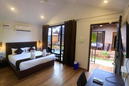 a bedroom with a large bed and a balcony at Molly's Nest in Mandrem