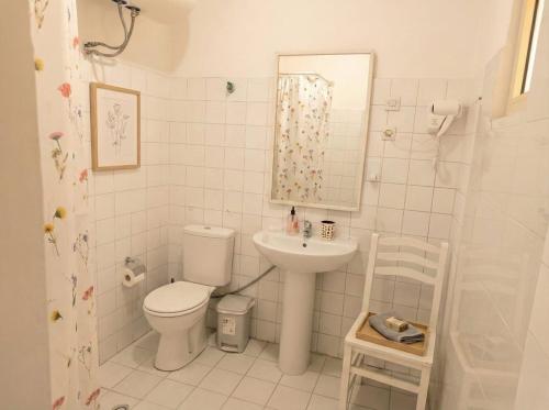 a white bathroom with a toilet and a sink at Orange City Center in Tirana