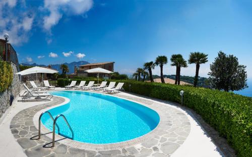 a swimming pool with lounge chairs and a resort at Villa Favara in Scala