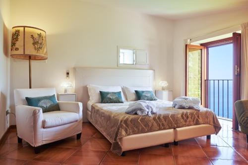 a bedroom with a large bed and a chair at Villa Favara in Scala