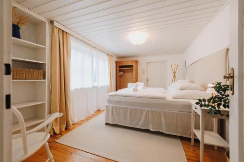 a white bedroom with a bed and a window at Natur & Ruhe - Ferienhaus Alexandra in Ebensee