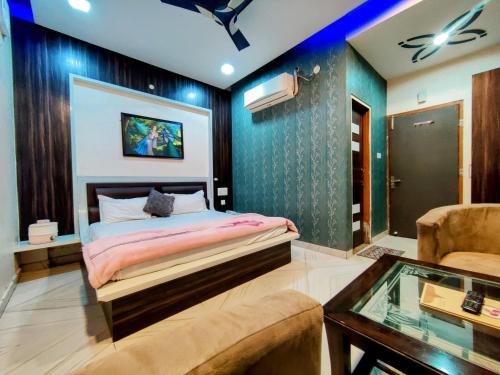 a bedroom with a bed and a couch and a table at Hotel Sanwariya in Kot Pūtli