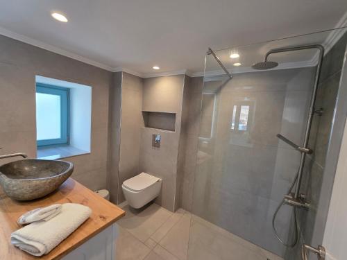 a bathroom with a shower and a toilet and a sink at Akti luxury aparts in Frý