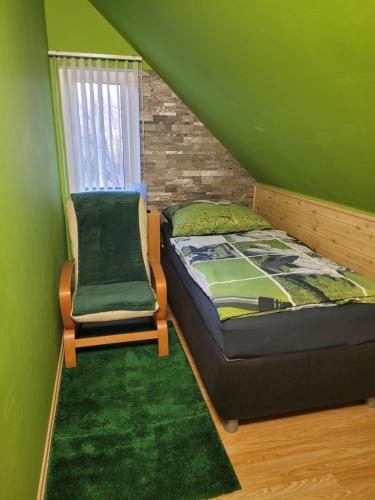 a small bedroom with a bed and a chair at Penzion U Elišky in Liberec