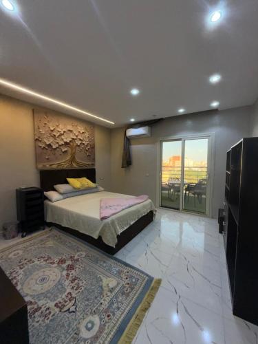 a bedroom with a bed and a large window at شقة للإيجار طنطا in Tanta