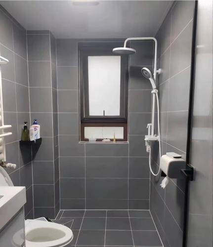 a bathroom with a shower with a toilet and a window at MaMa ShuShu Homestay in Sapa