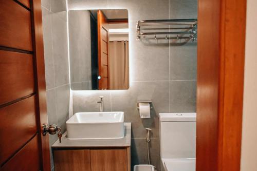a bathroom with a sink and a toilet and a mirror at Casa De Una Tagaytay in Galicias