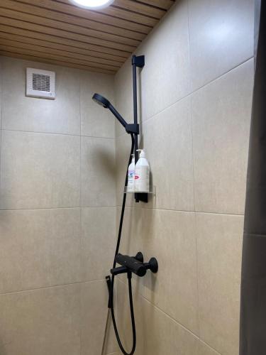 a shower with a blow dryer on a wall at HALLA-mökki in Tyrnävä