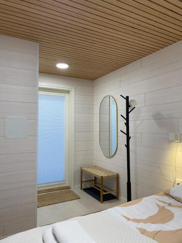 a bedroom with a bed and a mirror and a table at HALLA-mökki in Tyrnävä