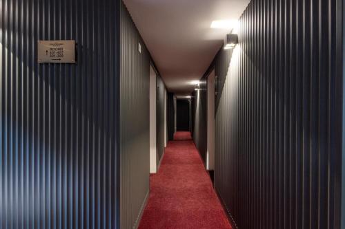 a hallway with a red carpet and a sign on a wall at Hotel Johannisberg Bad Homburg in Bad Homburg vor der Höhe