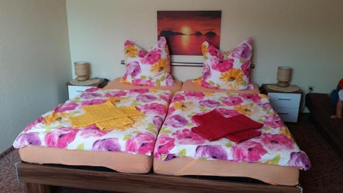 2 Betten mit bunten Decken und Kissen darauf in der Unterkunft Zimmervermietung M&R Bertuch in Jüterbog