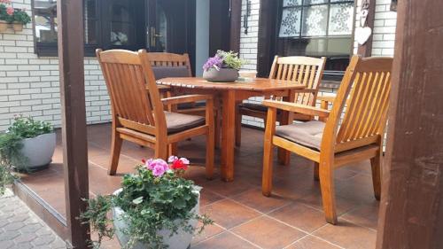 einen Holztisch und Stühle auf einer Terrasse in der Unterkunft Zimmervermietung M&R Bertuch in Jüterbog