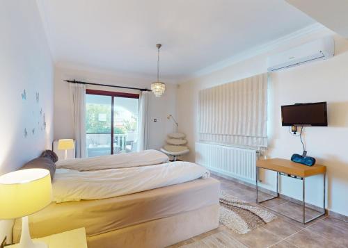 a bedroom with a large bed and a television at Villa Olive View in Kyrenia