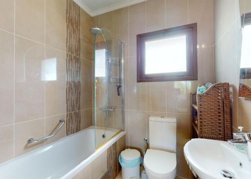 a bathroom with a tub and a toilet and a sink at Villa Olive View in Kyrenia