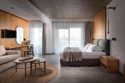 ein Hotelzimmer mit einem Bett und einer Couch in der Unterkunft The Oak Hotel in Keramotí