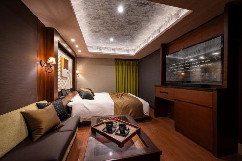ein Hotelzimmer mit Bett und Flachbildfernseher in der Unterkunft ホテル ゼン横浜町田 in Yokohama