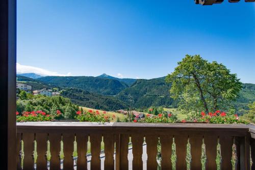 a balcony with a view of mountains and flowers at Garni-Residence Villa Paul in Nova Ponente