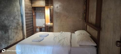 a bedroom with a white bed with towels on it at เวียงล้านนา รีสอร์ท in Ban Muang Pha