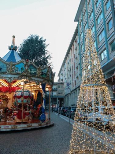 a christmas tree on a street with a carousel at La tana di Pumba in Cuneo